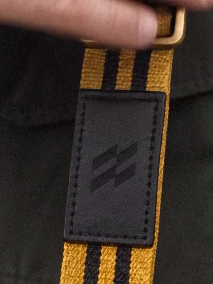 A rifle strap stamped with the Skyrons mark, a rifle being loaded and a hunter taking aim